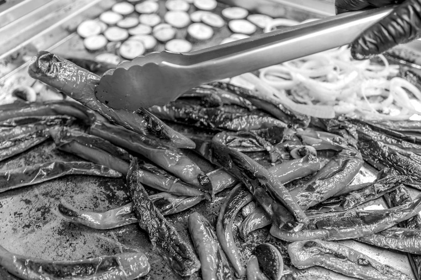 Piments verts grillés à la plancha dans la cuisine de Lucien, pris à la pince